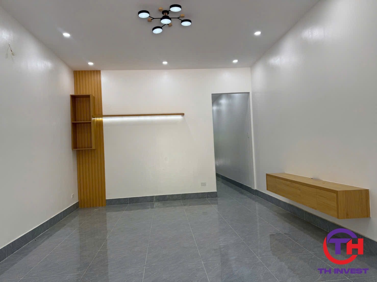 Phòng khách nhà trệt KĐT 5A có vách gỗ nan và kệ tivi treo